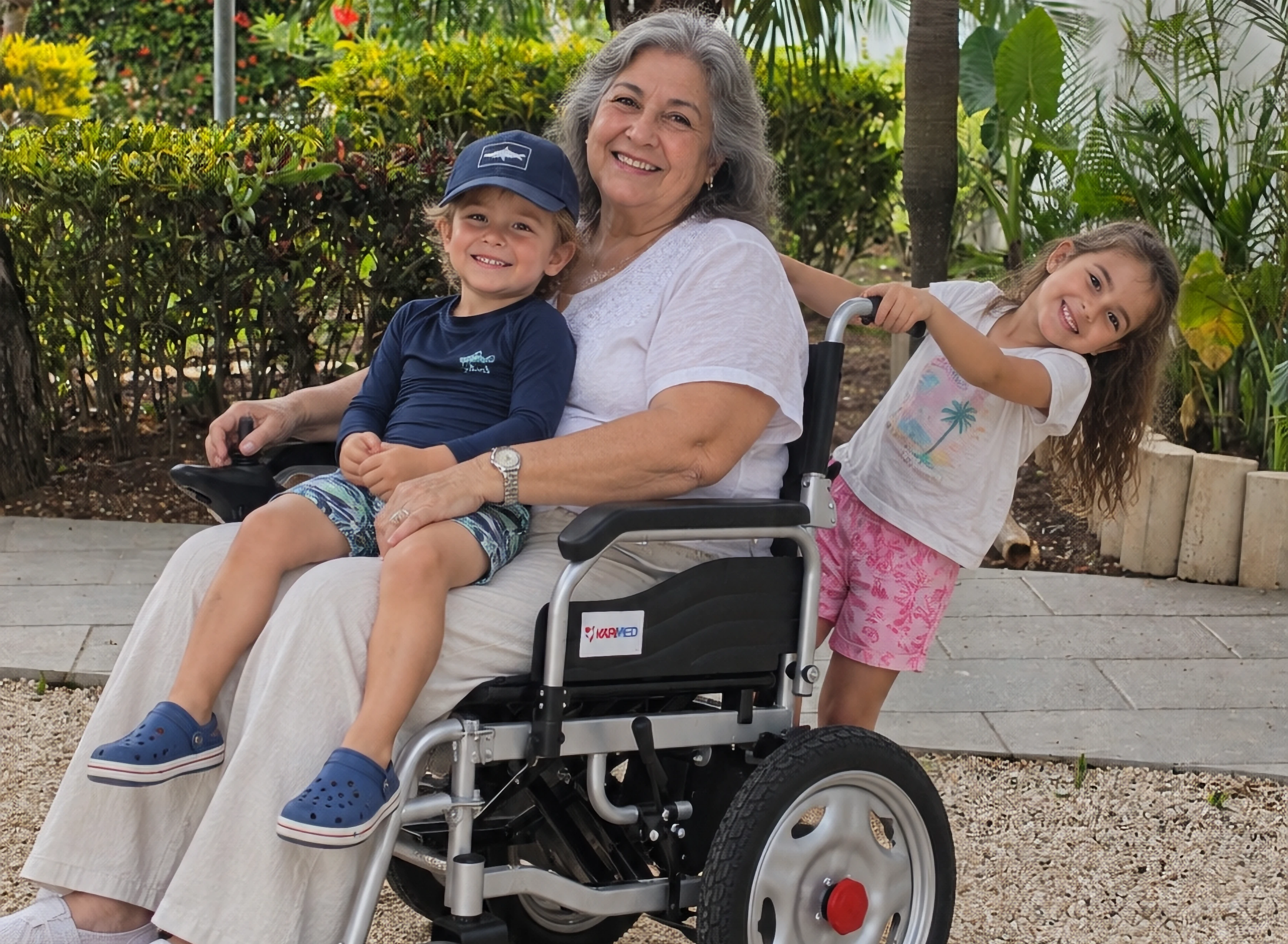 A woman in an electric wheelchair with two children.