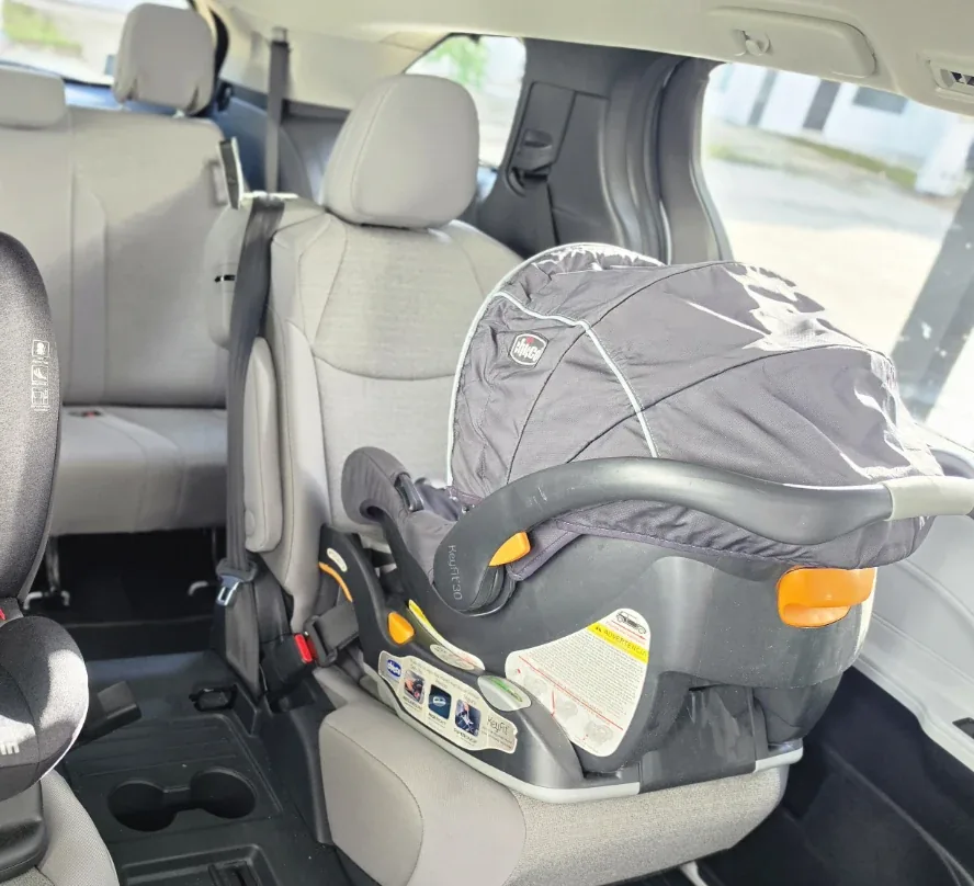 Installed rear-facing infant car seat in a spacious private tour vehicle