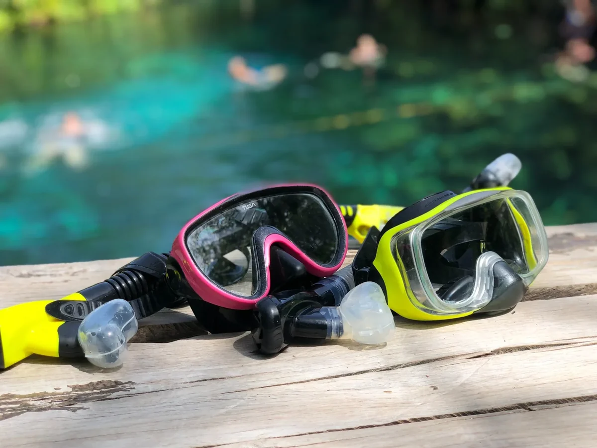 Premium snorkel masks and snorkels ready beside a clear cenote