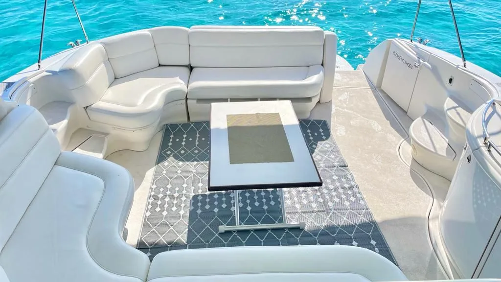 Tritón aft lounge with white seating and a table