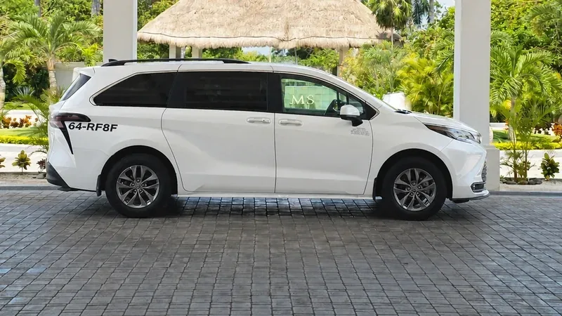 White Toyota Sienna beside a covered hotel entrance